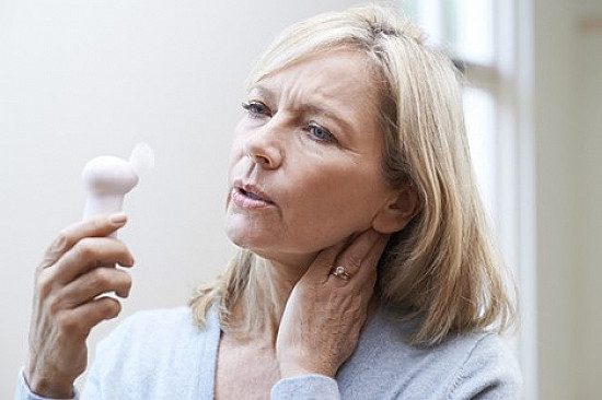Femme ressentant une bouffée de chaleur liée aux fluctuations hormonales de la périménopause.